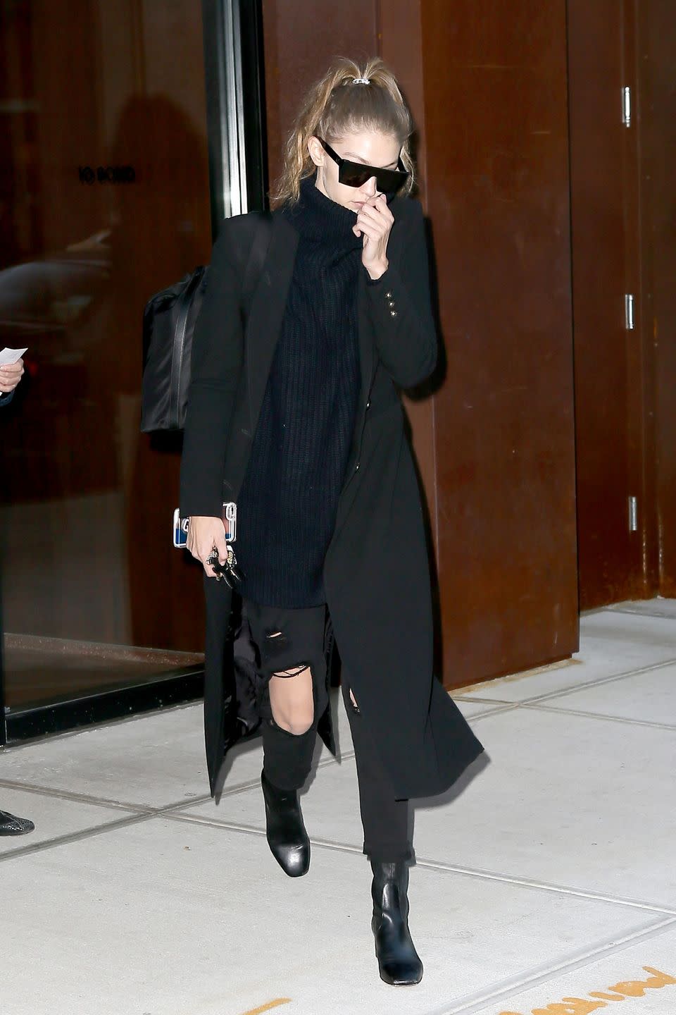 <p>Heading to New York's JFK airport, Gigi wore a black turtleneck with distressed <a href="http://www.7forallmankind.com/josefina-with-open-holes-in-black-/d/13158C26506?CategoryId=3310" rel="nofollow noopener" target="_blank" data-ylk="slk:7 For All Mankind;elm:context_link;itc:0" class="link ">7 For All Mankind</a> jeans, a black Smythe coat and Sandro ankle boots. </p>