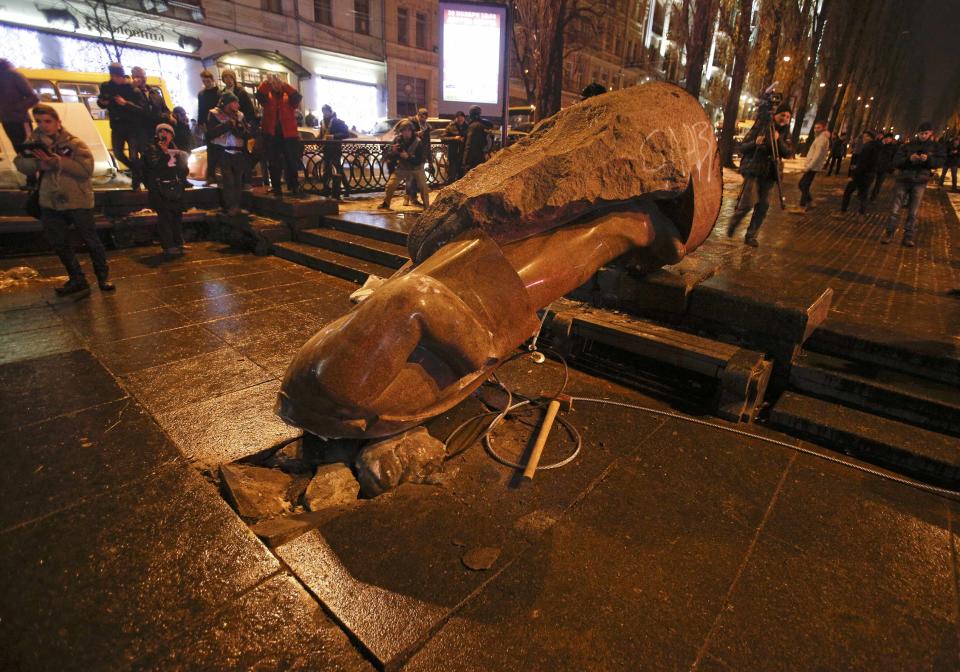 People surround a statue of Soviet state founder Vladimir Lenin, which was toppled by protesters during a rally organized by supporters of EU integration in Kiev