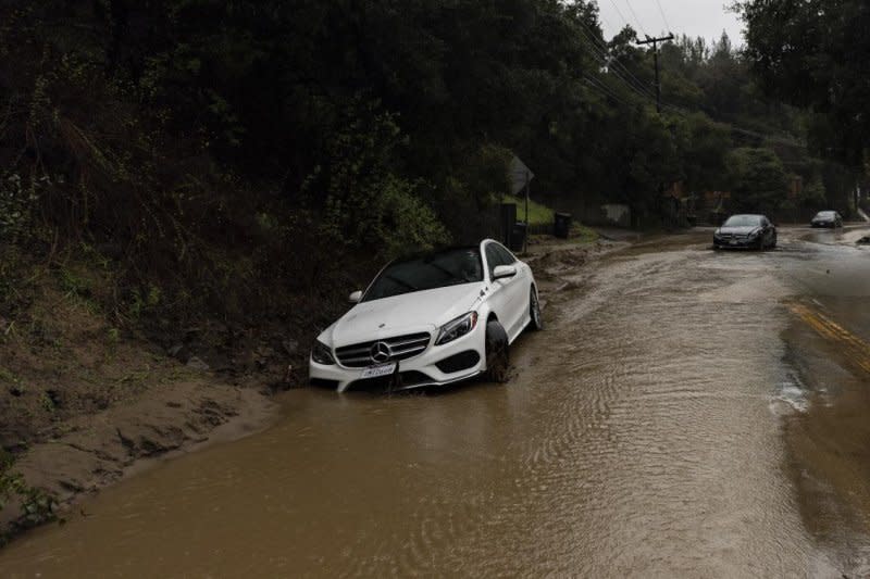 Vehicles impacted by a mudslide are abandoned on a road as a deadly storm sweeps through Southern California on Monday, bringing torrential rains and high winds that have killed at least three people. Los Angeles recorded more than 10 inches of rain in the last 24 hours, according to the National Weather Service. Photo by Etienne Laurent/EPA-EFE/