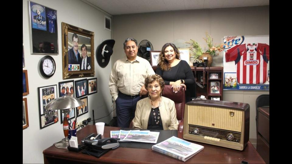 Ed Reyes and Diana Reyes-Ramer stand above their mom, Clara Reyes, in a family photo at the Dos Mundos office. Clara Reyes, the founder of the bilingual newspaper Dos Mundos in Kansas City, passed away Feb. 17 at age 86.