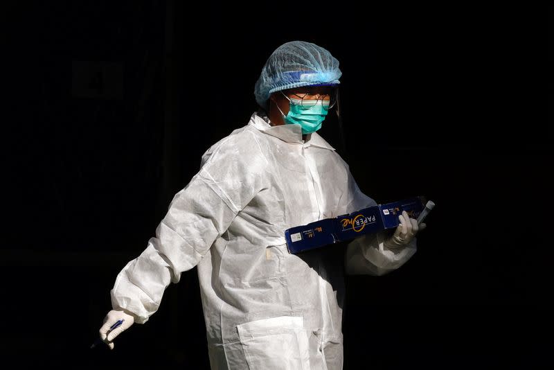 A medical worker in a protective suit walks at a makeshift community testing centre for the coronavirus disease (COVID-19), in Hong Kong