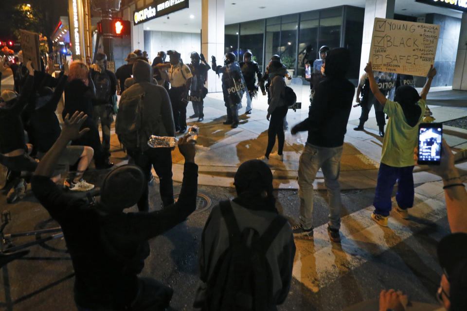 Protesters speak to Virginia Commonwealth University police who expressed solidarity with the marchers during a third night of unrest Sunday May 31, 2020, in Richmond, Va. Gov. Ralph Northam issued a curfew for this evening. (AP Photo/Steve Helber)