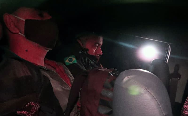 FILE PHOTO: Queiroz, former advisor and former driver of Senator Flavio Bolsonaro, is seen next to a police officer as he leaves the Homicide and Personnel Protection Department of the Civil Police in Sao Paulo