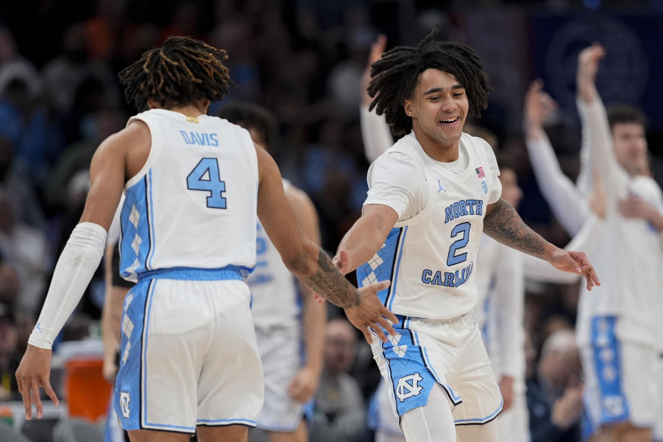 North Carolina guards RJ Davis (4) and Elliot Cadeau (2) celebrate during the second half of an NCAA college basketball game against Florida State in the quarterfinal round of the Atlantic Coast Conference tournament, Thursday, March 14, 2024, in Washington. (AP Photo/Susan Walsh)