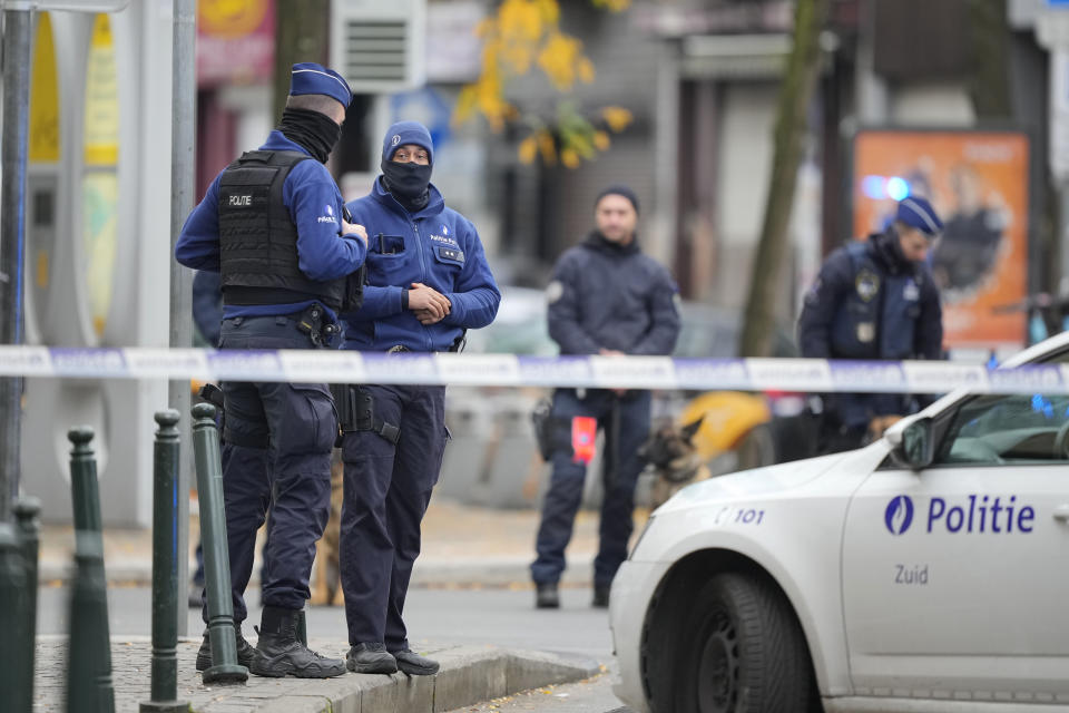 Belgian Police stand behind a cordoned off area close to where a suspected Tunisian extremist has been shot dead hours after manhunt looking for him Tuesday, Oct. 17, 2023. Police in Belgium have shot dead a suspected Tunisian extremist accused of killing two Swedish soccer fans in a brazen attack on a Brussels street before disappearing into the night on Monday. (AP Photo/Martin Meissner)