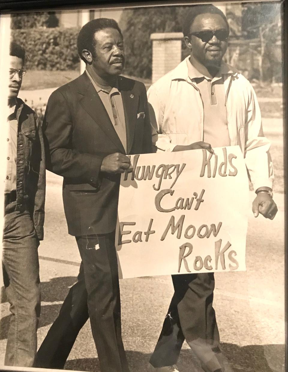 In 1969, civil rights leader Ralph Abernathy, at left holding the sign, came to Daytona Beach to join a march to Cape Canaveral to protest the launch of the Apollo 11 because so much money had been spent on that and not trying to eradicate poverty. Pictured at right is Charles Cherry Sr., a city commissioner, head of the local NAACP and community leader in Daytona Beach until his death in 2004.