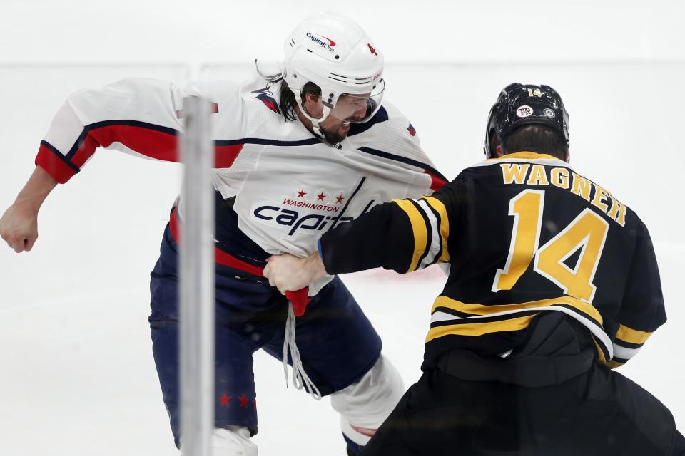 Washington Capitals' Brenden Dillon and Boston Bruins' Chris Wagner (14) fight during the first period of an NHL hockey game, Sunday, April 11, 2021, in Boston. (AP Photo/Michael Dwyer)