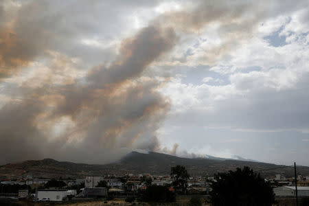 A village is seen amid smoke as a wildfire burns in Kineta, near Athens, Greece, July 23, 2018. REUTERS/Alkis Konstantinidis