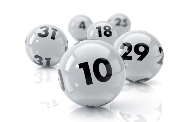 Six lottery balls on a white reflective table