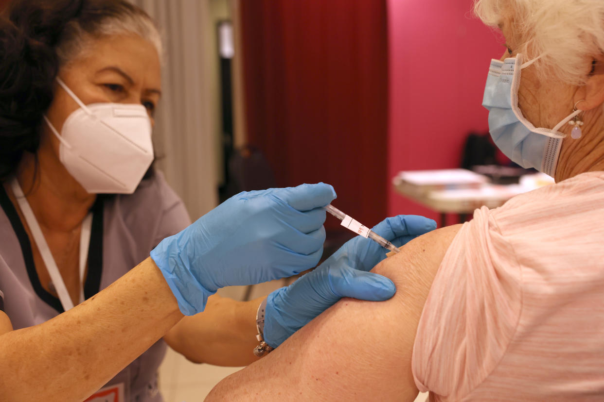 Registered Nurse Orlyn Grace (L) administers a COVID-Nurse Orlyn Grace administers a COVID-19 booster to Jeanie Merriman at a clinic in San Rafael, Calif., in April. 19 booster vaccination to Jeanie Merriman (R) at a COVID-19 vaccination clinic on April 06, 2022 in San Rafael, California. (Justin Sullivan/Getty Images)