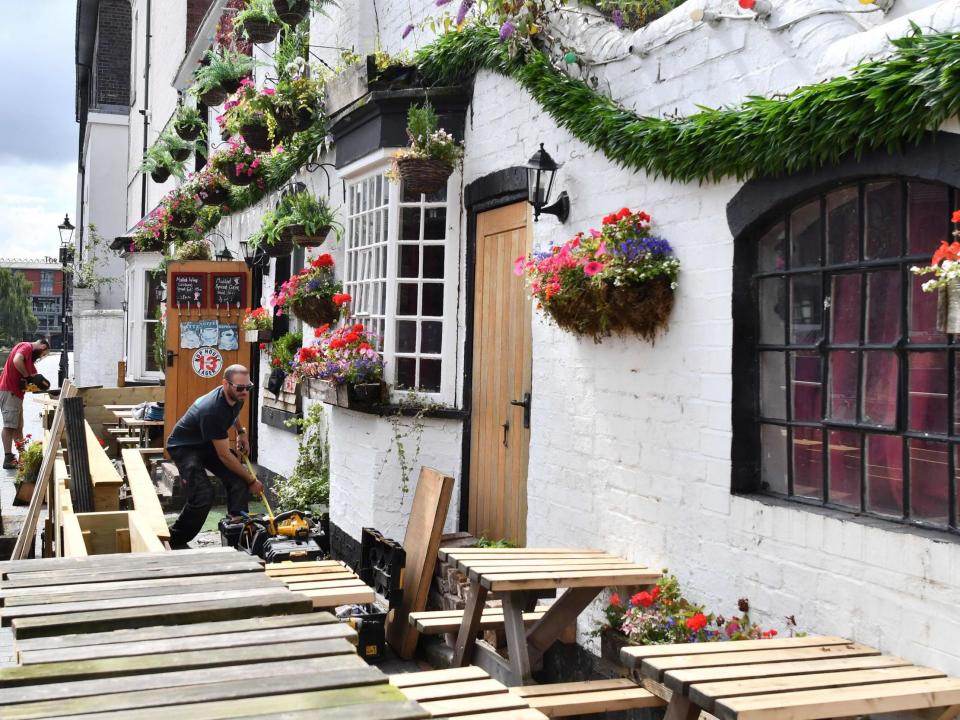 Workers prepare an outdoor seating area at a pub in Birmingham on 2 July, 2020, ahead of "super Saturday": JUSTIN TALLIS/AFP via Getty Images)