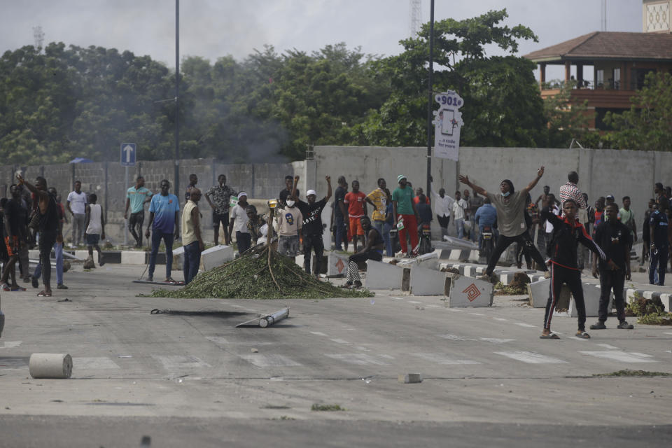 People protest against alleged police brutality, near the Lekki toll gate in Lagos, Nigeria, Wednesday Oct. 21, 2020. After 13 days of protests against alleged police brutality, authorities have imposed a 24-hour curfew in Lagos, Nigeria's largest city, as moves are made to stop growing violence. ( AP Photo/Sunday Alamba)