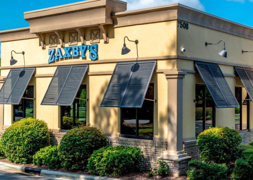 One story yellow and brown building with blue centered sign that says Zaxby's. 