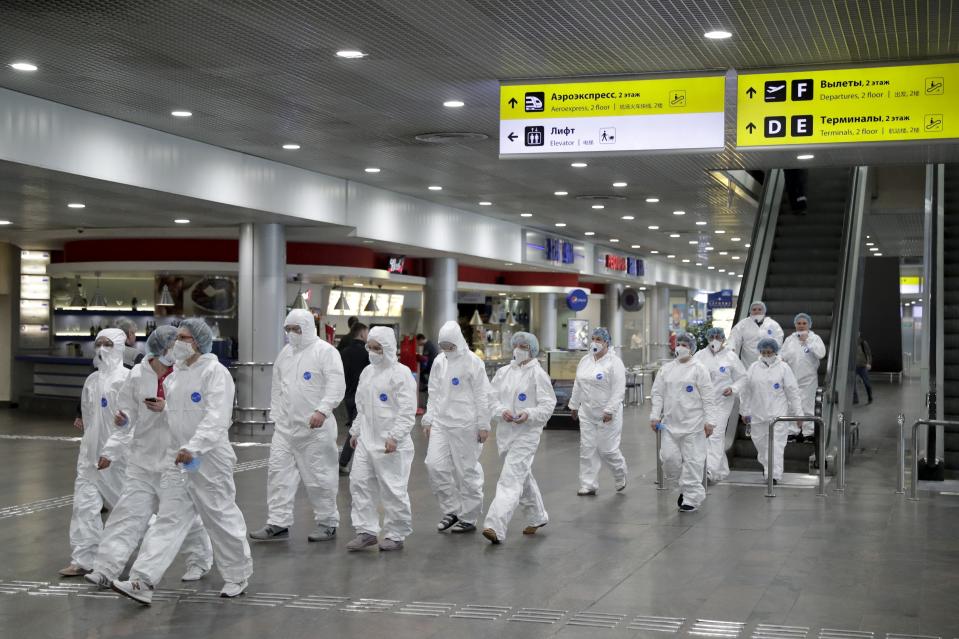 Russian medical experts walk to start their shift to check passengers arriving from foreign countries at Sheremetyevo airport outside Moscow, Russia, Thursday, March 19, 2020. Authorities in Russia are taking vast measures to prevent the spread of the COVID-19 virus in the country. The measures include closing the border for all foreigners, shutting down schools for three weeks, sweeping testing and urging people to stay home. For most people, the new coronavirus causes only mild or moderate symptoms. For some it can cause more severe illness. (AP Photo/Pavel Golovkin)