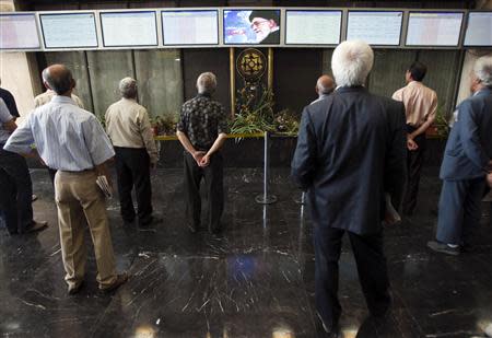 Iranian investors check an electronic board showing stock information at the Tehran Stock Exchange in this August 3, 2010 file photo. REUTERS/Stringer/Files