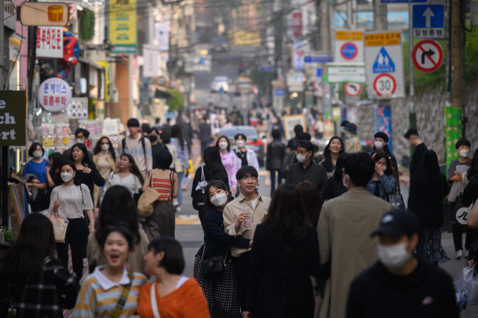 In a photo taken on May 10, 2020, people wearing face masks walk along a street in the Hongdae district of Seoul. - South Korea announced its highest number of new coronavirus cases for more than a month on May 11, driven by an infection cluster in a Seoul nightlife district just as the country loosens restrictions. (Photo by Ed JONES / AFP) (Photo by ED JONES/AFP via Getty Images)