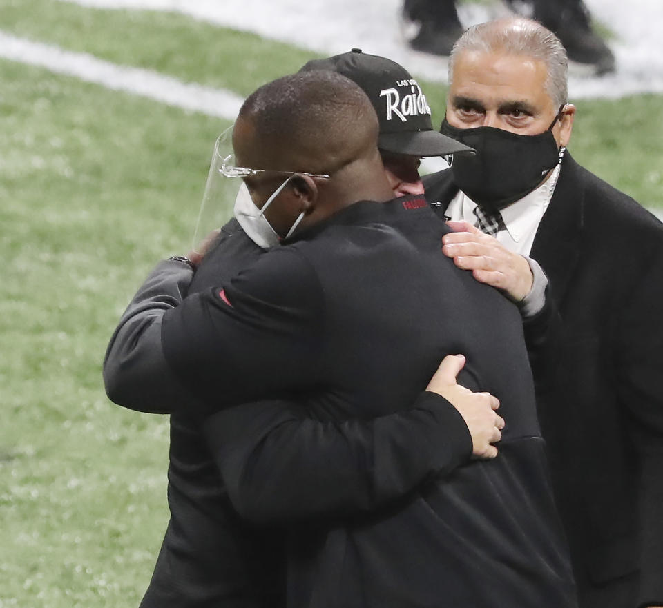 Atlanta Falcons head coach Raheem Morris, left, and Las Vegas Raiders head coach Jon Gruden greet each other with a hug after the Falcons defeated the Raiders in an NFL football game on Sunday, Nov 29, 2020, in Atlanta. (Curtis Compton/Atlanta Journal-Constitution via AP)