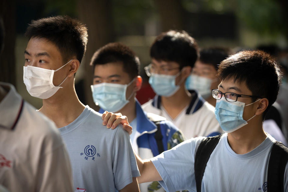 Students wearing face masks to protect against the new coronavirus line up for the first day of China's national college entrance examinations, known as the gaokao, in Beijing, Tuesday, July 7, 2020. China's college entrance exams began in Beijing on Tuesday after being delayed by a month due to the coronavirus outbreak. (AP Photo/Mark Schiefelbein)