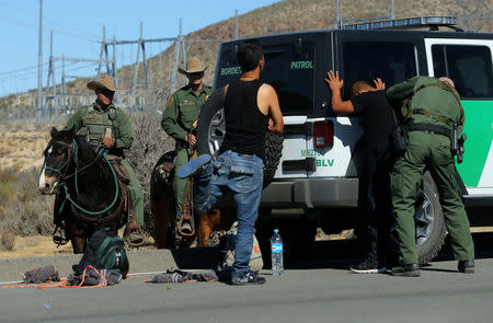 U.S. Border Patrol supervisor Bobby Stine frisks a man a few hundred meters from the U.S.-Mexico border fence near Jacumba, California, U.S., November 14, 2016. REUTERS/Mike Blake