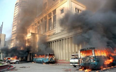 Vehicles in Dhaka burn after an opposition rally which ended with police using tear gas and batons after the election was announced - Credit: AFP