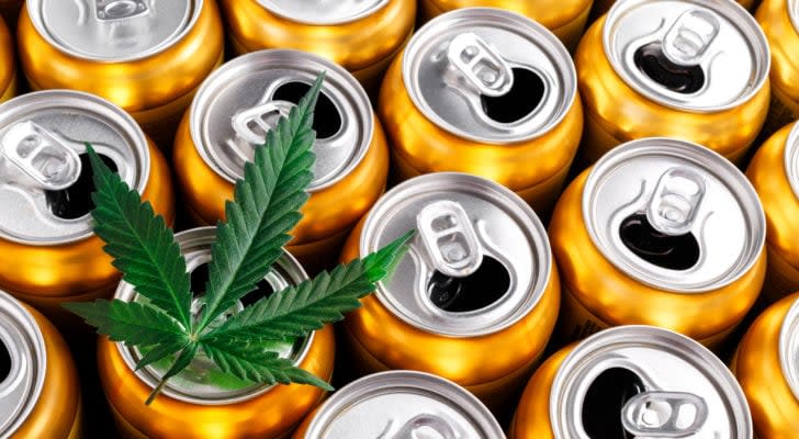 A marijuana leaf rests atop one of dozens of aluminum beverage cans.