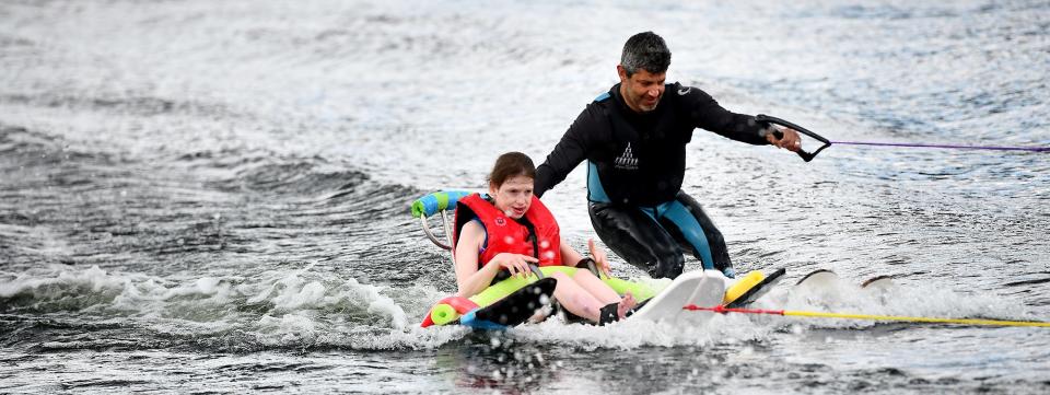 Rachel Doyle, left, of Webster, leaves a nice wake behind her as she water skis with Gary Naples of Holland Aqua Riders during Friday's Adaptive Skiing at the Webster Water Ski Collective on Lake Quinsigamond in Shrewsbury.