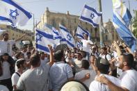 FILE - In this May 10, 2021, file photo, Israelis wave national flags during a Jerusalem Day parade, in Jerusalem. Israel’s new government on Monday, June 14 approved a contentious parade by Israeli nationalists through Palestinian areas around Jerusalem's Old City, setting the stage for possible renewed confrontations just weeks after an 11-day war with Hamas militants in the Gaza Strip. Hamas called on Palestinians to “resist” the march. (AP Photo/Ariel Schalit, File)