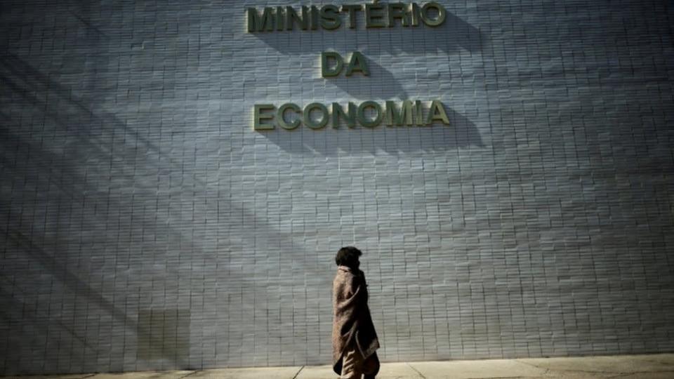 Moradora de rua passa em frente a letreiro do Minist&#xe9;rio da Economia