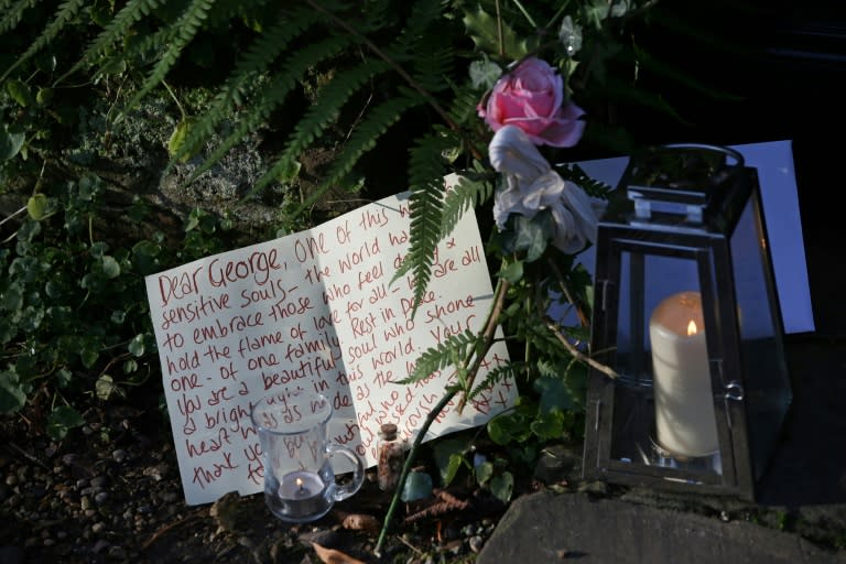 A message of condolence is pictured beside candles and a single rose outside the north London home of British singer George Michael on December 26, 2016