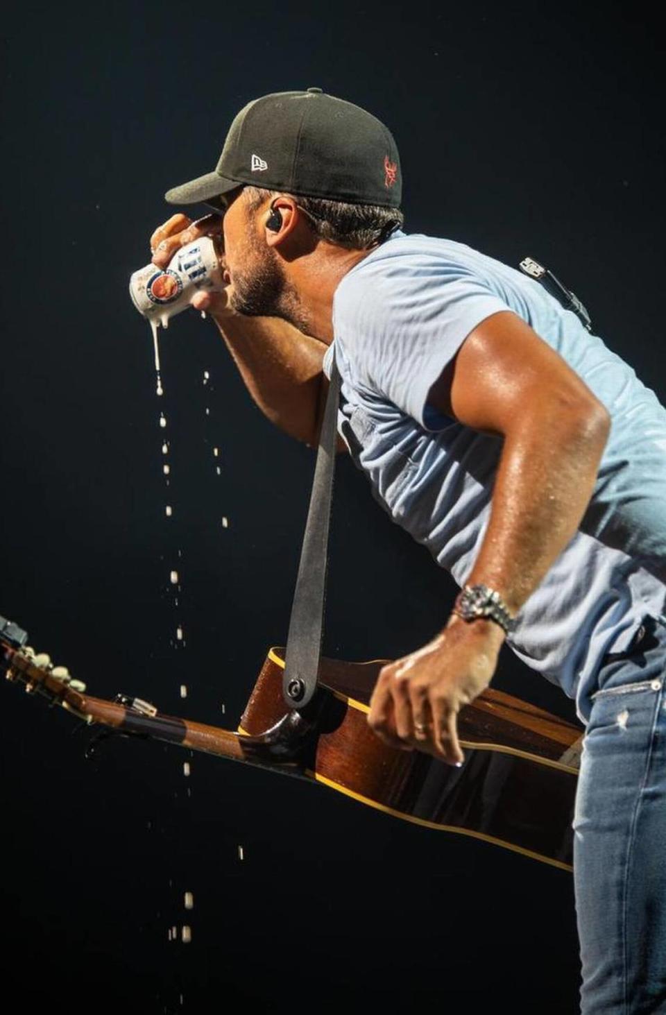 No, this doesn’t work as a Two Lane ad. But this is just to reinforce how much Luke Bryan — shown quenching his thirst between songs at PNC Music Pavilion in June 2018 — enjoys drinking beer.