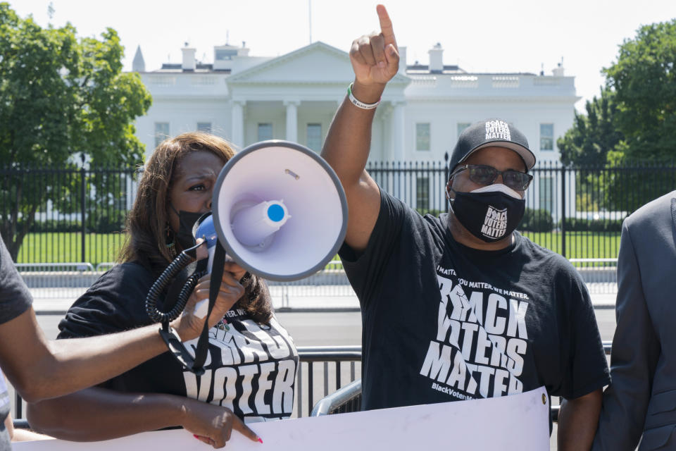 LaTosha Brown, left, and Cliff Albright, both with Black Voters Matter, rally for voting rights, Tuesday, Aug. 24, 2021, near the White House in Washington. (AP Photo/Jacquelyn Martin)