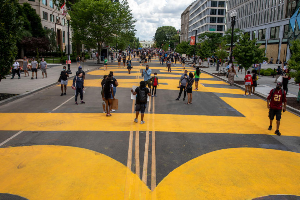 People walk down 16th street after volunteers, with permission from the city, painted "Black Lives Matter" on the street near the White House. Source: Getty Images