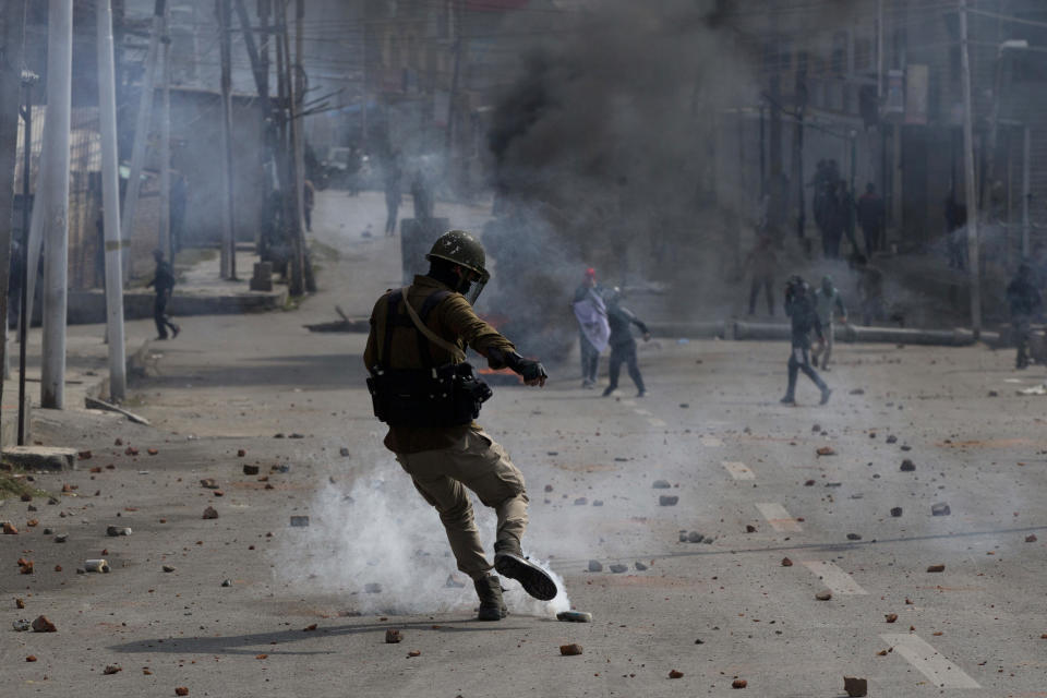 In this Wednesday, Oct. 17, 2018, file photo, an Indian policeman kicks an exploded teargas shell thrown back at them by Kashmiri protesters near the site of a gunbattle in Srinagar, India. Anti-India protests and clashes erupted in the main city of disputed Kashmir on Wednesday shortly after a gunbattle between militants and government forces killed at least two suspected rebels and a counterinsurgency police official. (AP Photo/Dar Yasin, File)