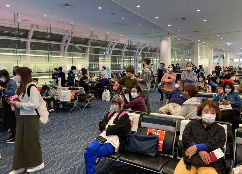 Travelers line up to board a Hawaii-bound flight from Tokyo's Haneda International Airport during Japan's "Golden Week" holidays, in Tokyo