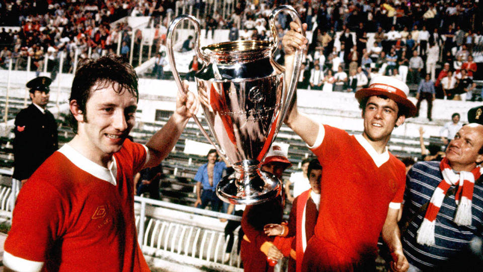 Pictured right, Ray Kennedy helps raise one of the European Cups he won with Liverpool.