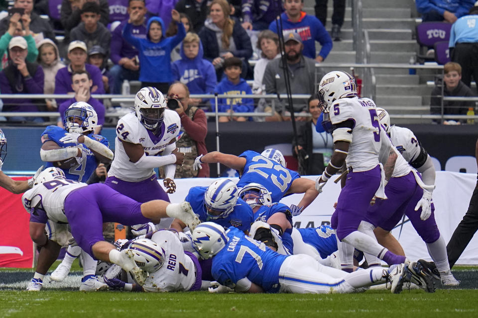 Air Force fullback Emmanuel Michel, top left, rushes for a touchdown against James Madison during the first half of the Armed Forces Bowl NCAA college football game, Saturday, Dec. 23, 2023, in Fort Worth, Texas. (AP Photo/Julio Cortez)