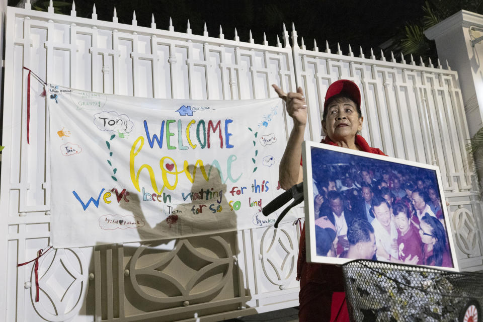 <strong>有支持者舉著戴克辛的照片在其住處前守候，門上還掛著「歡迎回家」的布條。（圖／美聯社）</strong>
