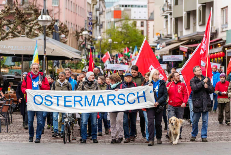 A rally participant holds a poster showing Benjamin Netanyahu, Israeli Prime Minister, and Olaf Scholz, German Chancellor, demonstrating against the conflict in Gaza during the Easter marches in Hesse. Andreas Arnold/dpa