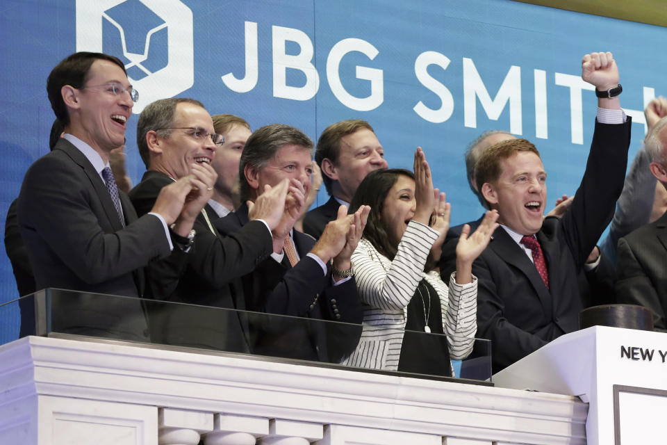 JBG Smith CEO W. Matthew Kelly, right, is applauded as he rings the New York Stock Exchange opening bell, Wednesday, July 26, 2017, to celebrate the closing of the spin-off/merger transaction between JBG and Vornado/Charles E. Smith. (AP Photo/Richard Drew)