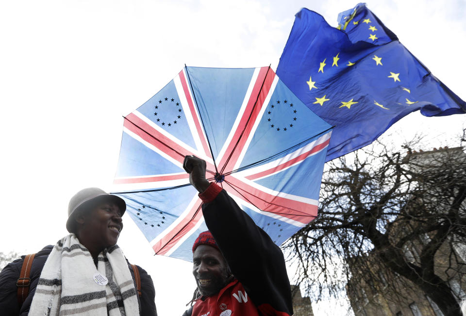 Anti-Brexit Demonstranten halten einen Regenschirm mit Aufdruck der Flagge von Großbritannien und eine EU-Fahne. (Bild: Kirsty Wigglesworth/AP/dpa)