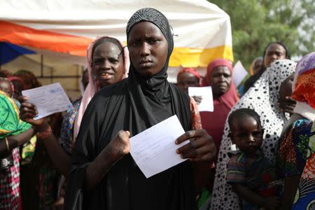 A woman, with a hand cut off, is seen with a food ration card in a queue to receive food supplement from World Food Programme (WFP) at the Banki IDP camp, Borno, Nigeria April 26, 2017. Picture taken April 26, 2017. REUTERS/Afolabi Sotunde