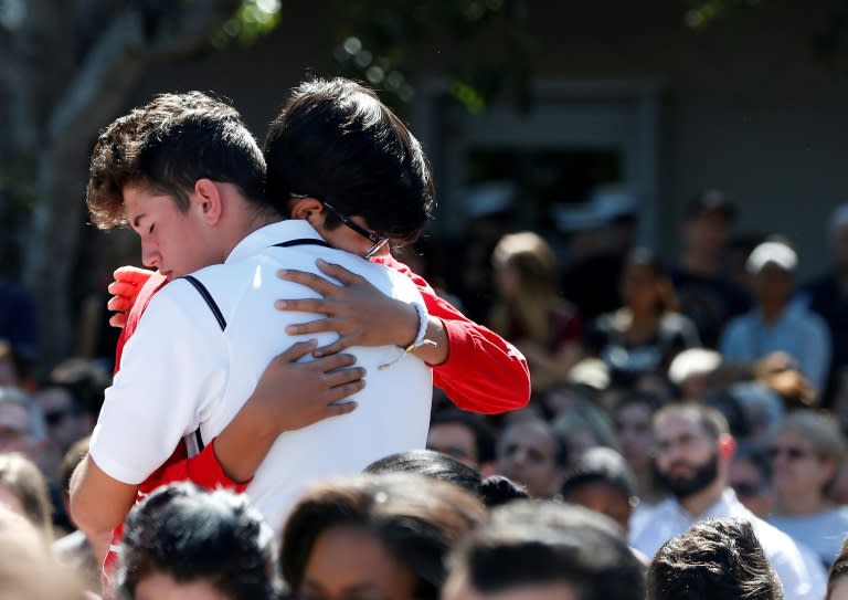 Mourners hug during a prayer vigil for the victims of the Florida school shooting