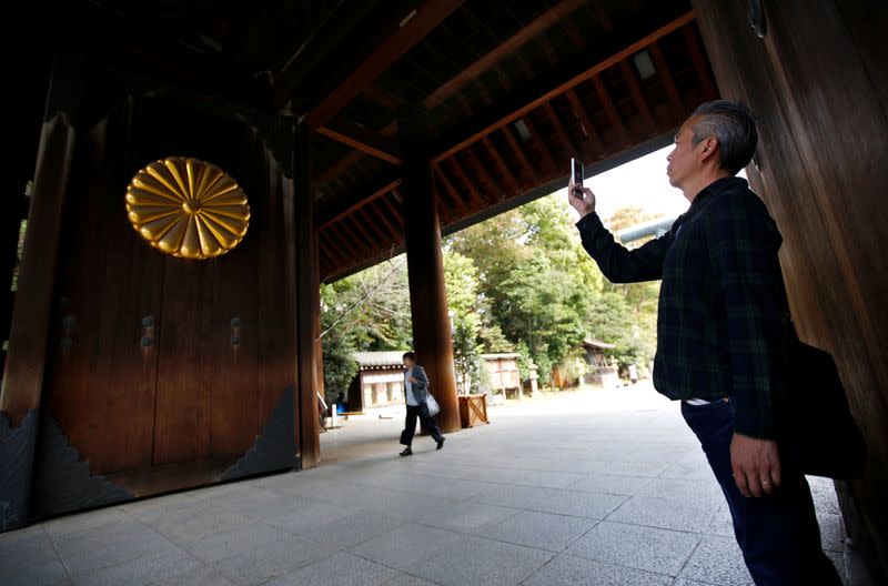 A visitor takes photo of the Imperial chrysanthemum emblem at the Yasukuni Shrine in Tokyo