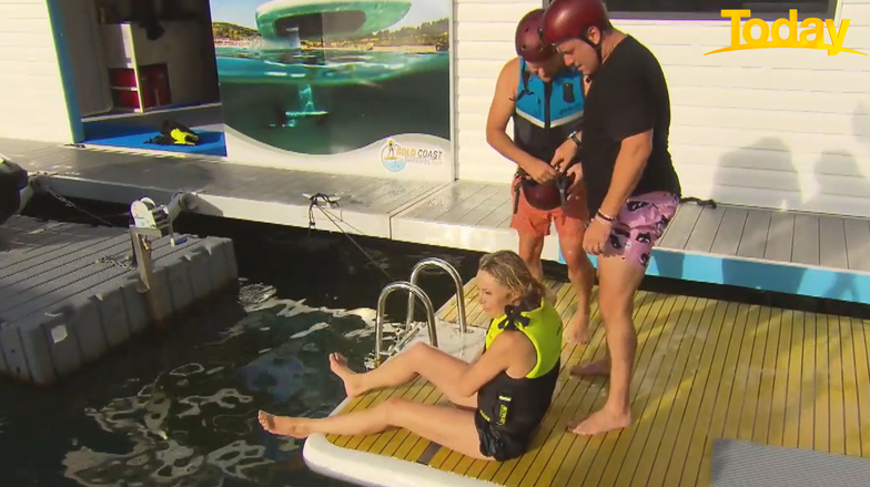 Today host Allison Langdon sits on a pontoon after injuring her knee during a watersports activity for the show as co-host Karl Stefanovic looks on