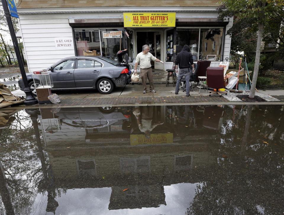 Charles Vartanian, left, and his son Chris clear out flood-damage items from his store in the wake of superstorm Sandy on Thursday, Nov. 1, 2012, in Little Ferry, N.J. Surprise coastal surge floods caused by the storm battered Little Ferry, Moonachie and some other towns along the Hackensack River in Bergen County _ all areas unaccustomed to flooding. (AP Photo/Mike Groll)