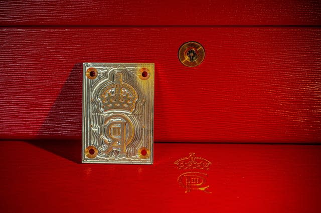 The brass engraved die which has been created to emboss the King’s cypher on to the famous red despatch boxes