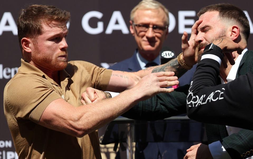 Canelo Alvarez slaps Caleb Plant during a face-off before a press conference - Getty Images