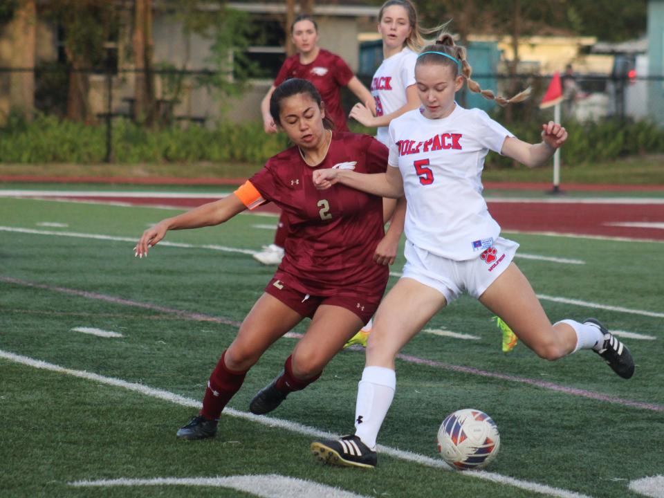 Wolfson midfielder Natalie Hall (5) clears the ball as Episcopal forward Skylar Dancel (2) challenges during an FHSAA District 3-3A girls soccer final on February 1, 2024. [Clayton Freeman/Florida Times-Union]