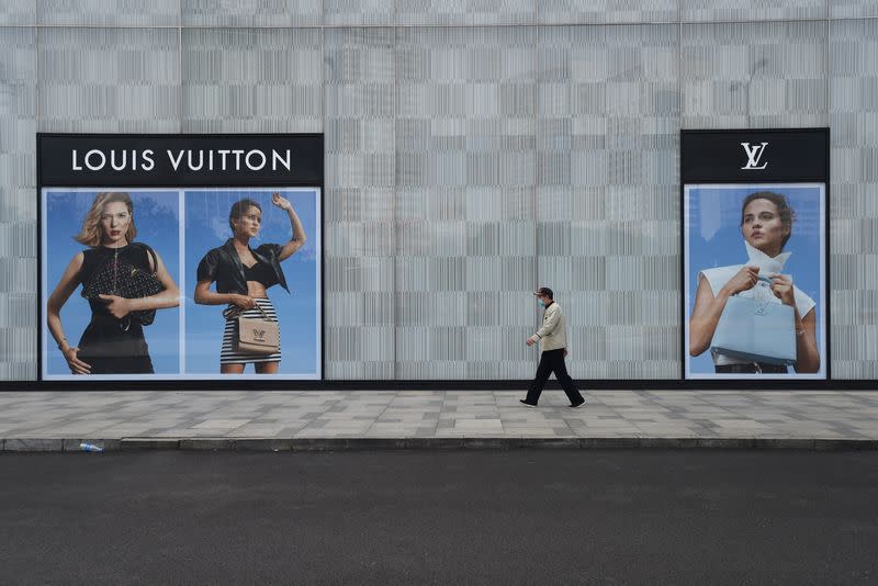 Man wearing a face mask walks past a store of French luxury brand Louis Vuitton in Wuhan, the epicentre of the novel coronavirus outbreak