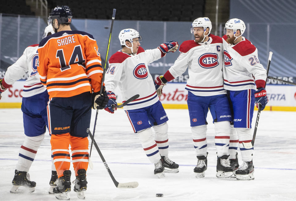 Edmonton Oilers' Devin Shore (14) skates past as Montreal Canadiens' Nick Suzuki (14), Shea Weber (6) and Jeff Petry (26) celebrate a goal during first-period NHL hockey game action in Edmonton, Alberta, Saturday, Jan. 16, 2021. (Jason Franson/The Canadian Press via AP)